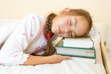 小女孩睡在一堆书上图片