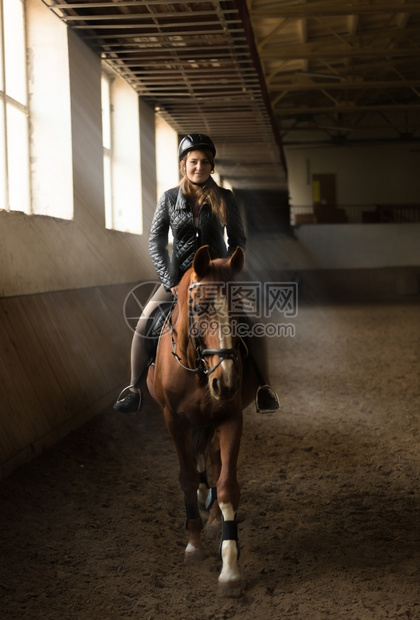 年轻女骑马在场的室内照片图片