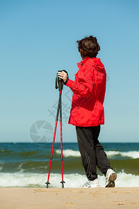 北欧人散步女在海滩上徒步旅行积极健康的生活方式图片