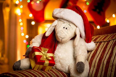 在圣诞客厅装饰的品盒里配上礼物的玩具羊近身镜头图片