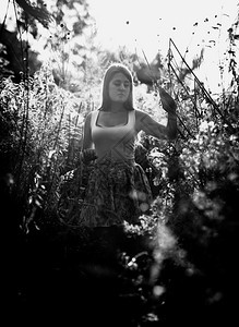 在草地高上行走的孤独女孩黑白画像图片