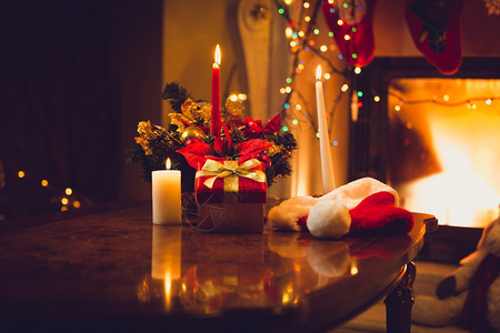 圣诞节前夕燃烧蜡烛壁炉和礼品盒的背景图片