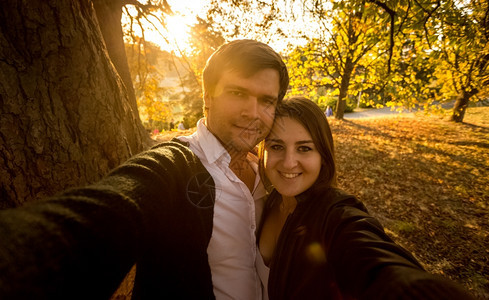 在日落的秋天公园浪漫情侣美自拍图片