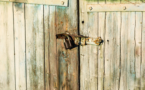 挂在木制谷仓门上的旧金属锁近照图片
