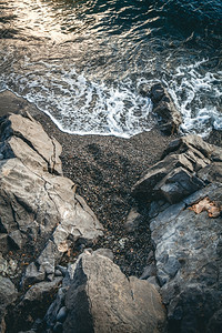 海浪覆盖日落时悬崖的美丽景色图片