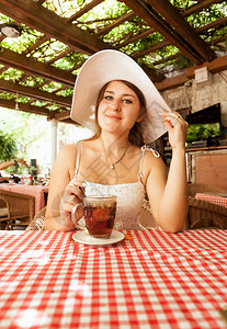 坐在咖啡厅喝茶的优雅女人肖像图片