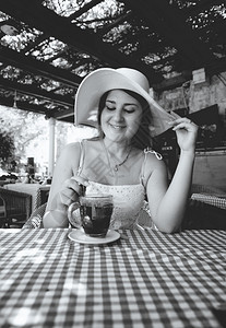 在咖啡馆喝茶吃早餐的可爱女人黑白肖像图片