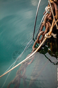 海水中旧绳索和生锈系链的近照片图片