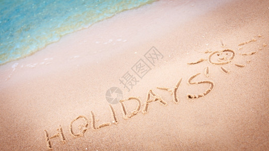 暑假概念在沙滩上的写着假期图片