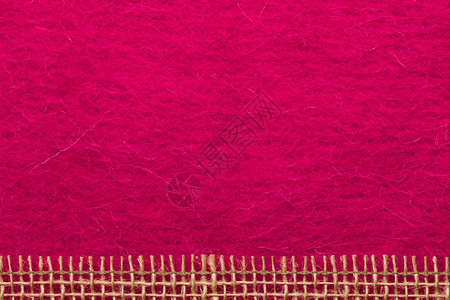 由粉红色纺织品背景上粗糙的布蓬绳网状形成的边框或背景图片