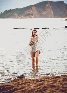 穿着白衬衫的年轻美女在海滩上出图片