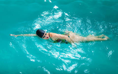 游泳竞争和娱乐女游泳者呼吸时表现的爬行风格游泳池边图片