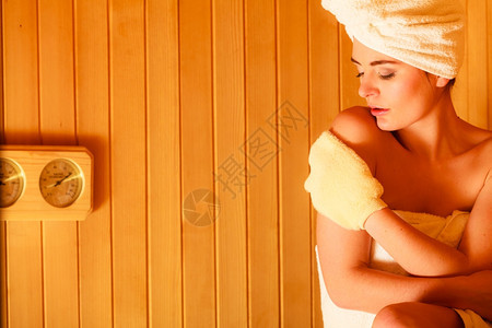 女白毛巾在木制桑拿室休息用脱花手套按摩图片