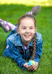 微笑的女孩在草地上玩乐抱着球图片