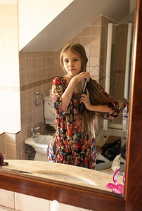 在浴室梳理头发的小女孩肖像图片