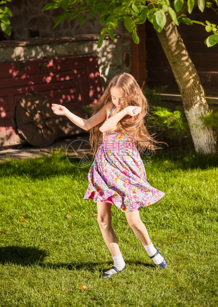 美丽的女孩在草地上跳舞图片