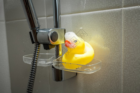 淋浴时被泡沫覆盖的黄橡胶鸭近照图片