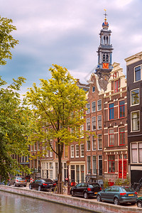 荷兰阿姆斯特丹运河教堂Westerkerk和典型房屋船只和自行车的城市景象图片