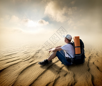 坐在沙漠看太阳的观光客图片