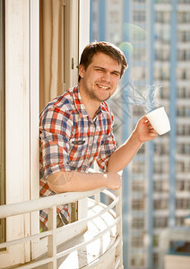 早上在阳台喝咖啡的男子肖像图片