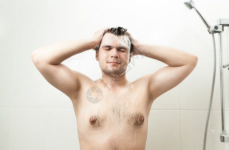 淋浴时洗头发的感笑男人肖像图片