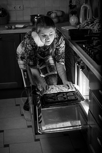 黑白女人在烤炉里放锅子的黑白女人肖像图片