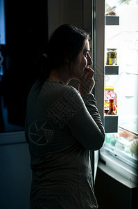 穿着睡衣的妇女肖像晚上打开冰箱图片