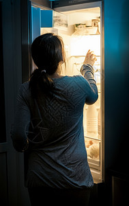 半夜在冰箱里看饥饿女人的肖像图片