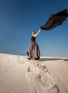 穿着长裙在沙丘上布长的妇女全肖像图片