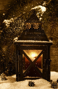 古老的金属灯笼古老概念里面放着红蜡烛底有柔软的落雪和绿树枝图片