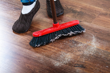 清洁家务概念关闭扫帚和女脚清洁工扫木地板图片