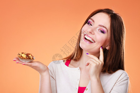 甜食面包和人的概念微笑女人手持蛋糕橙色背景图片