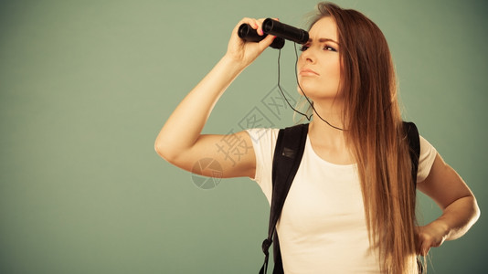暑假和旅游概念有吸引力的长头发妇女背包通过望远镜滤照片看图片