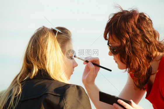 化妆美容程序和概念师在女眼睛上应用刷子色的眼线图片