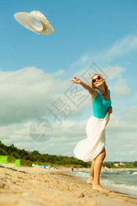 时装幸福和生活方式概念可爱的金发女孩在海滩上玩耍脱下帽子年轻女人在海边放松图片