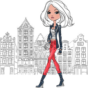 穿着皮夹克牛仔裤和红靴子的时装女游客穿着皮夹克牛仔裤和红靴子与传统的荷兰住宅一起走在阿姆斯特丹街的道上图片