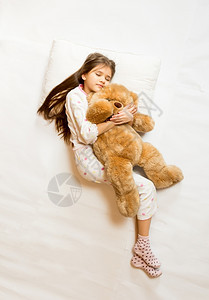 抱着泰迪熊的可爱睡美人孤立的一拍图片