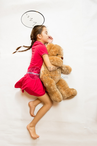 概念拍摄从最顶尖的视野可爱梦想女孩躺在大泰迪熊上图片