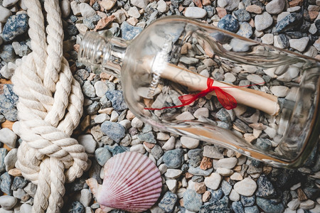 用洋绳和贝壳在海滨的瓶装信有海绳和贝壳图片