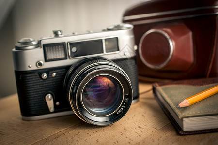 经典胶片相机和木制桌上笔记本图片