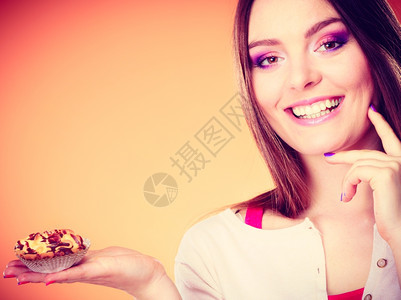 微笑的女人手持蛋糕橙色背景图片