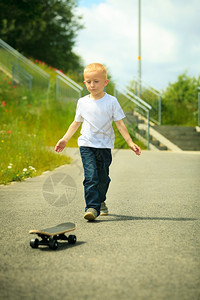 小男孩在户外玩滑板图片