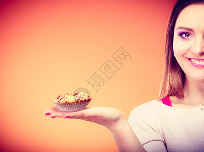 微笑的女人手持蛋糕橙色背景图片