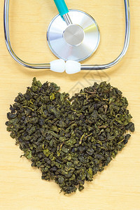 绿色茶叶心在木表面形成听诊器健康饮食以降低心脏病风险图片