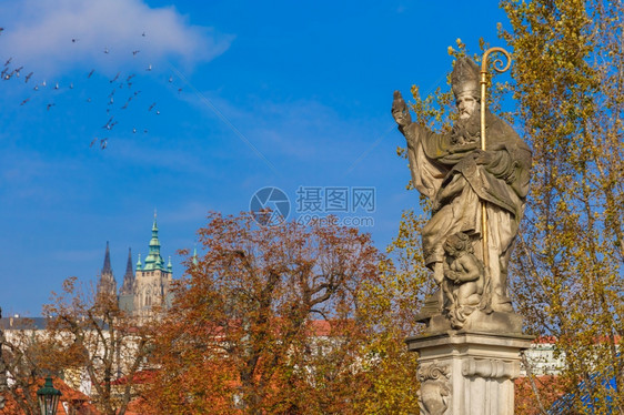 圣奥古斯丁雕刻的圣奥古斯丁雕刻着燃烧的心脏手在捷克布拉格CharlesBridge上践踏异教书籍图片