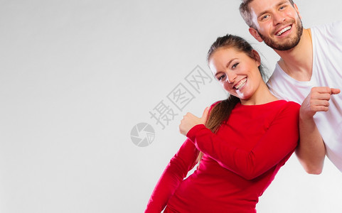 运动概念的年轻快乐情侣男女在灰色背景上拥有快乐的复制空间肖像图片