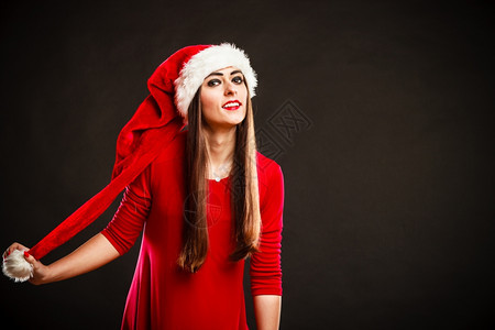 圣诞时间漂亮的女戴着圣达克萨斯帽子灰色背景工作室拍摄图片