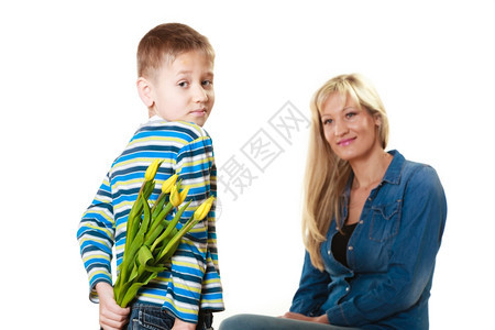 假日母亲概念后视小男孩背着一堆黄色的郁金香准备给母亲一个惊喜图片