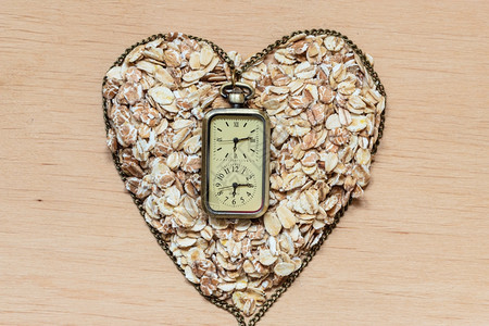 用于饮食保健概念的时间燕麦心脏形状和木质表面的观察用于降低胆固醇的健康食品保护心脏图片