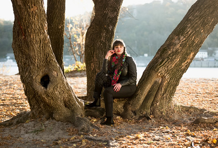坐在河边树下的女子图片